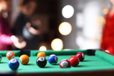 Photo of Many colorful billiard balls on green table indoors, closeup. Space for text