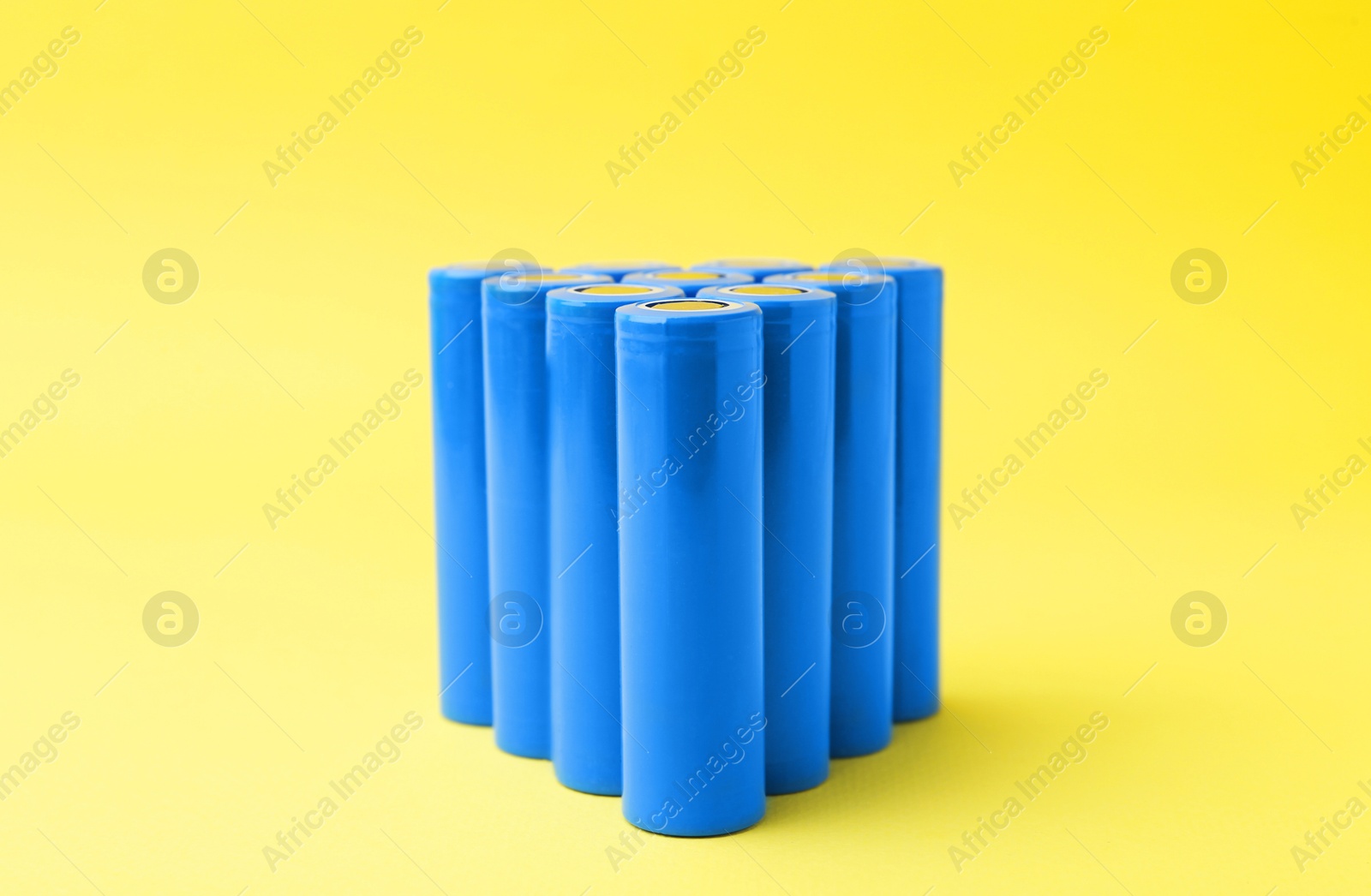 Photo of Many AA cell batteries on yellow background