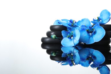 Photo of Beautiful blue orchid flowers and spa stones on mirror surface, space for text