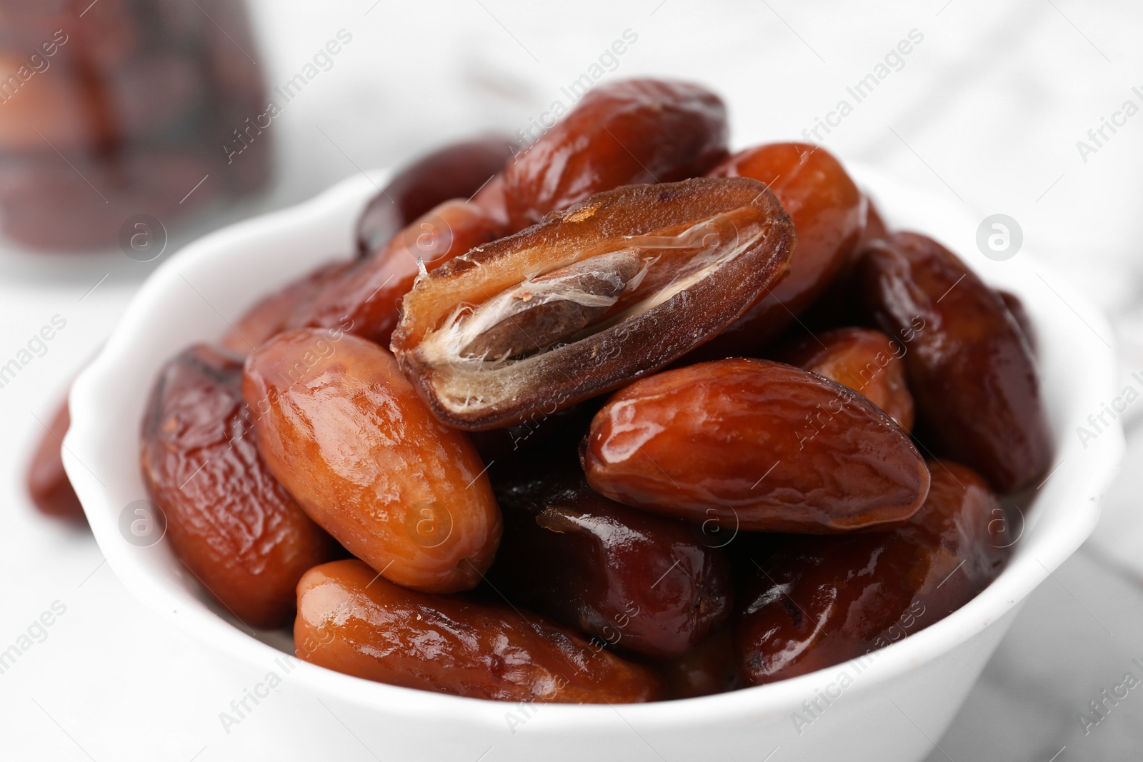 Photo of Tasty sweet dried dates in bowl on table, closeup