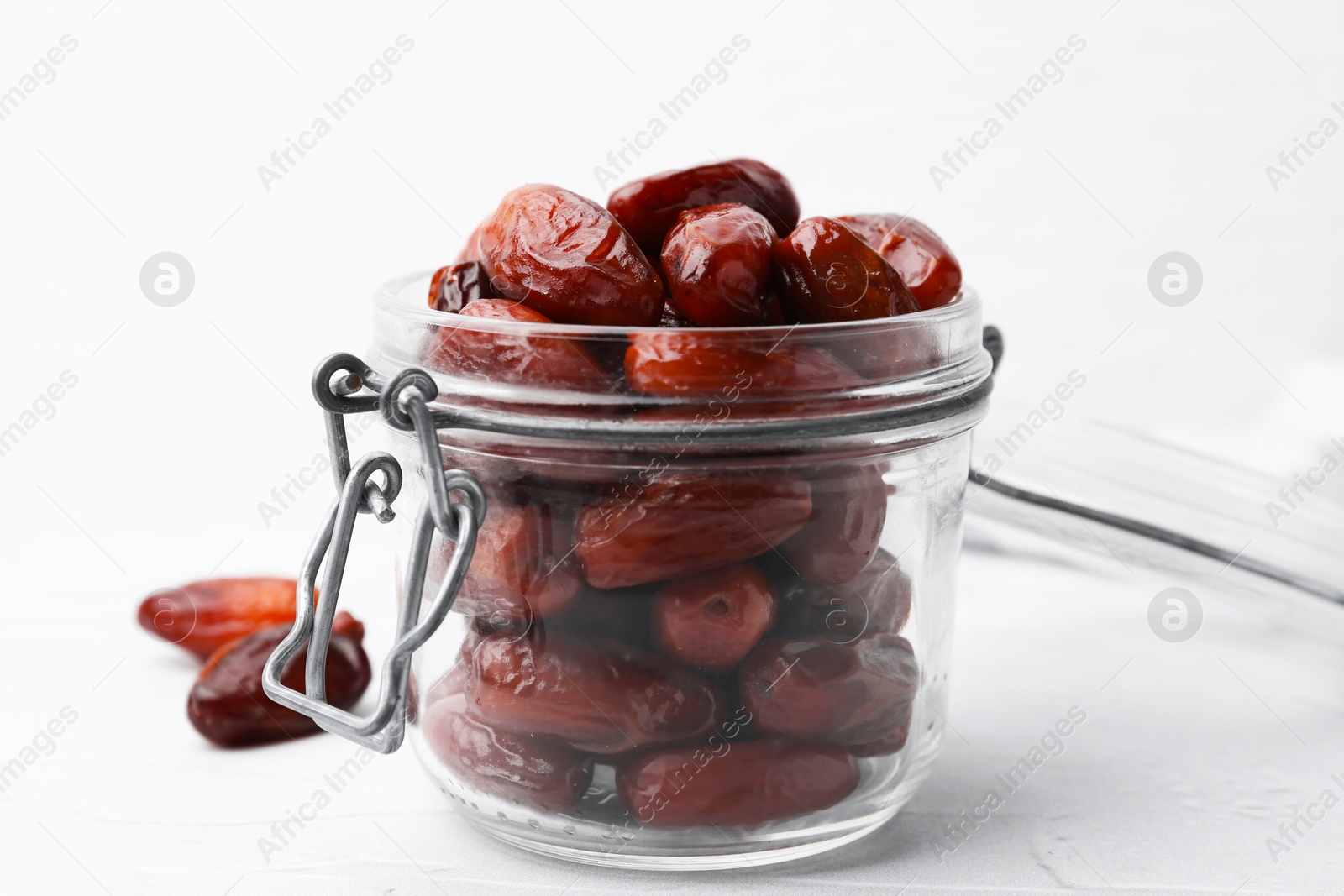 Photo of Tasty dried dates in jar on white table, closeup