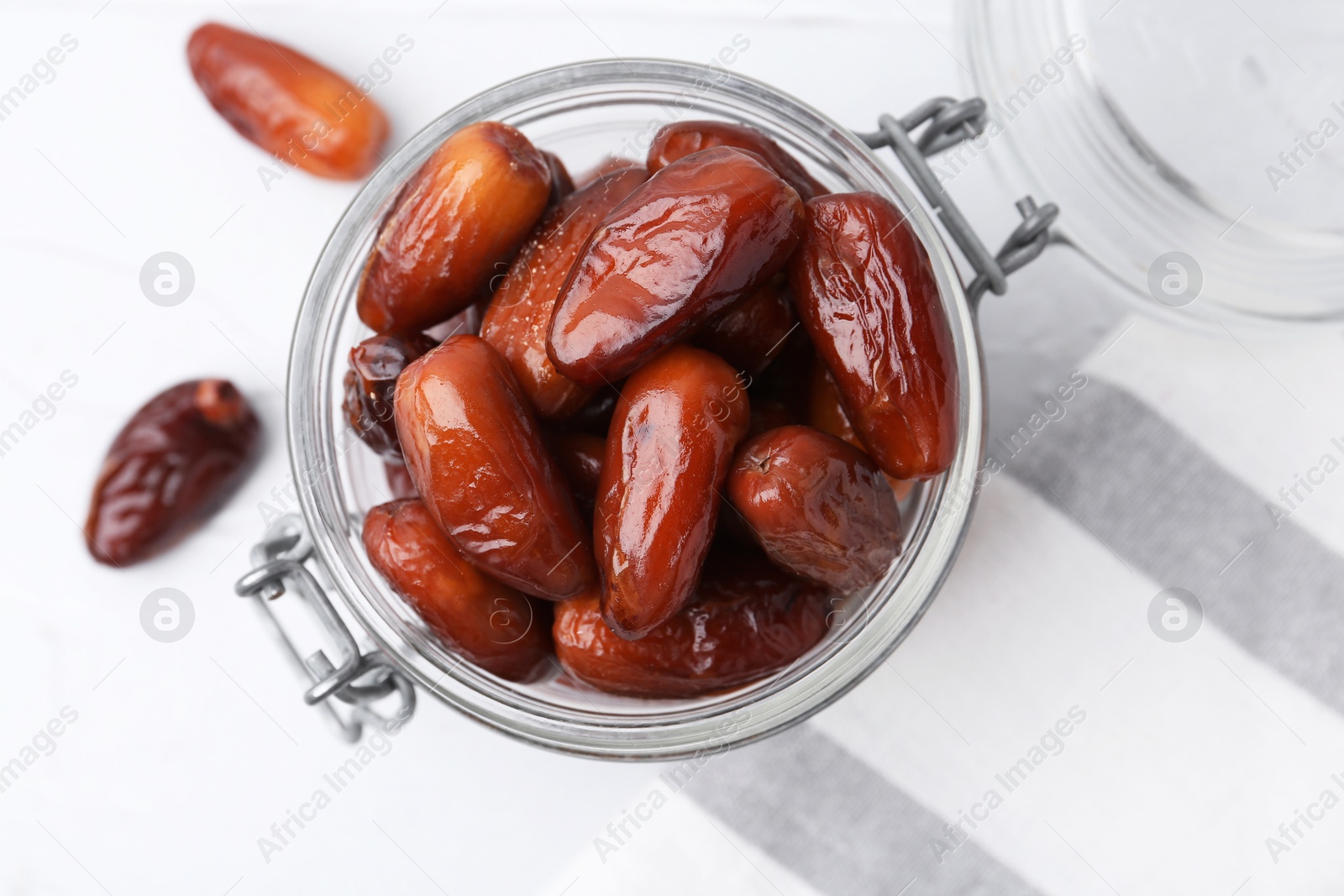 Photo of Tasty dried dates in jar on white table, top view