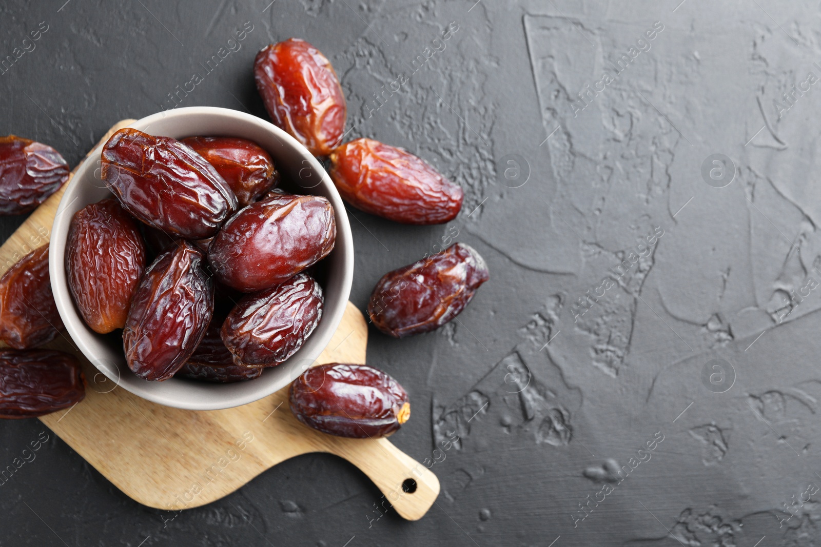 Photo of Tasty dried dates on grey table, top view. Space for text