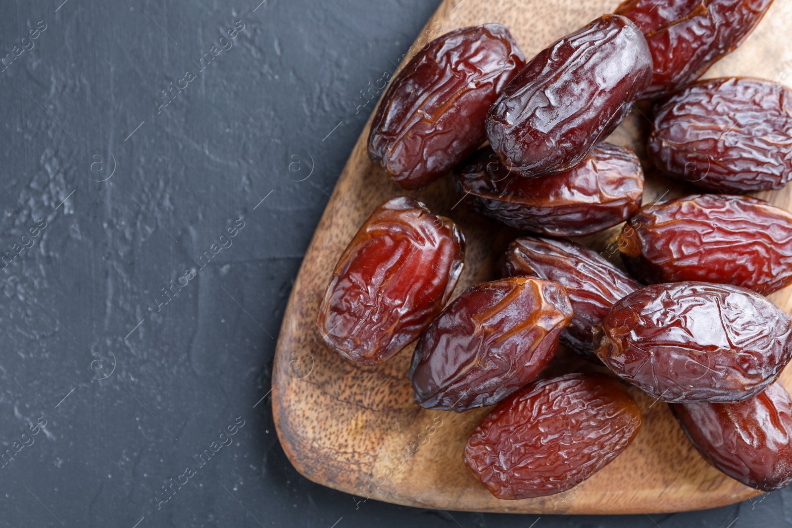 Photo of Tasty dried dates on grey table, top view. Space for text