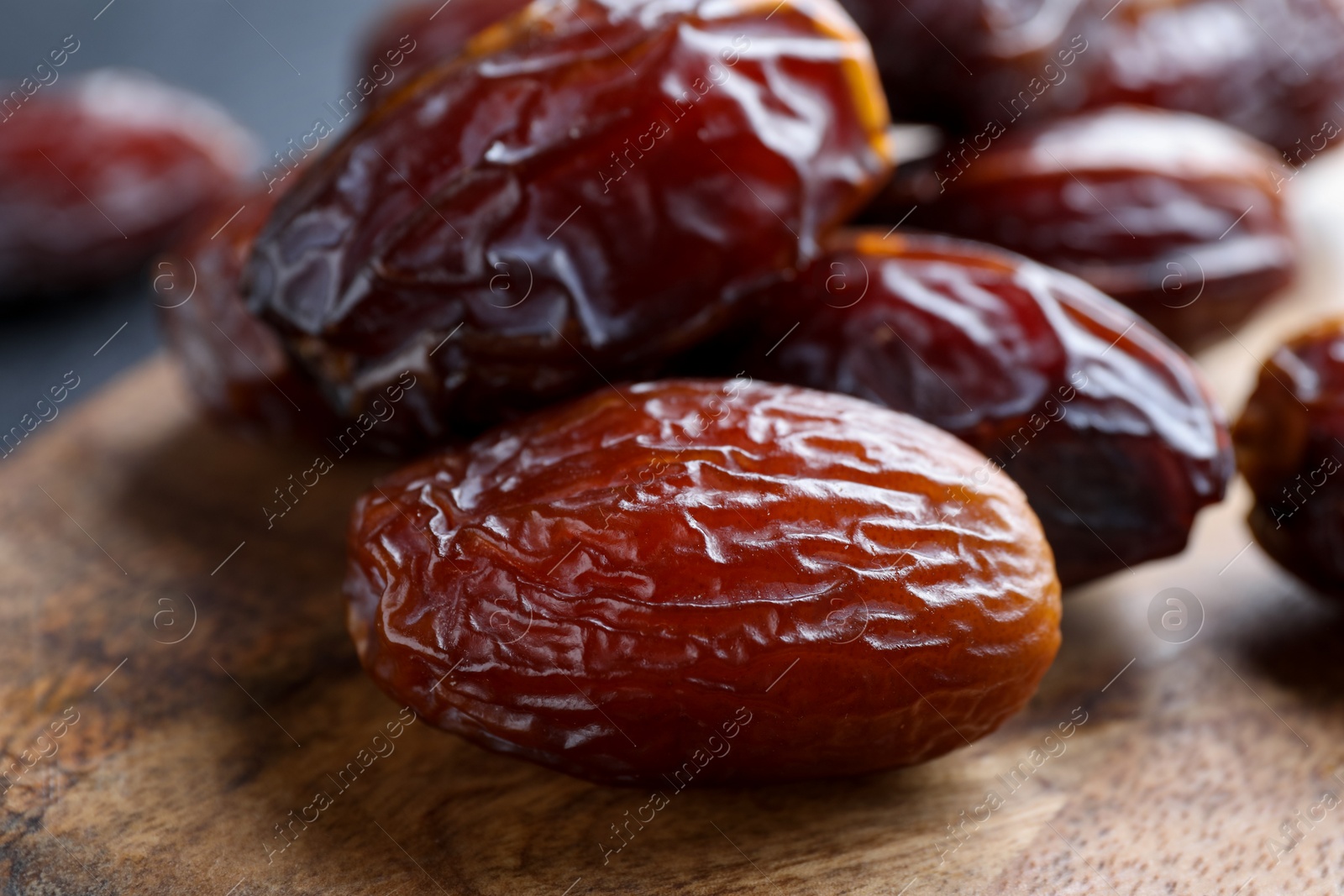 Photo of Tasty dried dates on wooden board, closeup