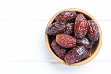 Photo of Tasty dried dates on white wooden table, top view. Space for text