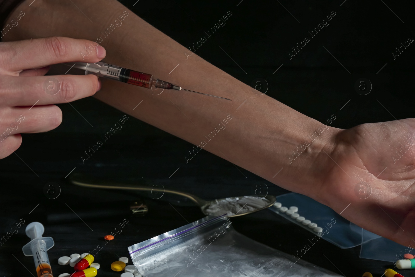 Photo of Drug addiction. Woman with syringe against dark background, closeup