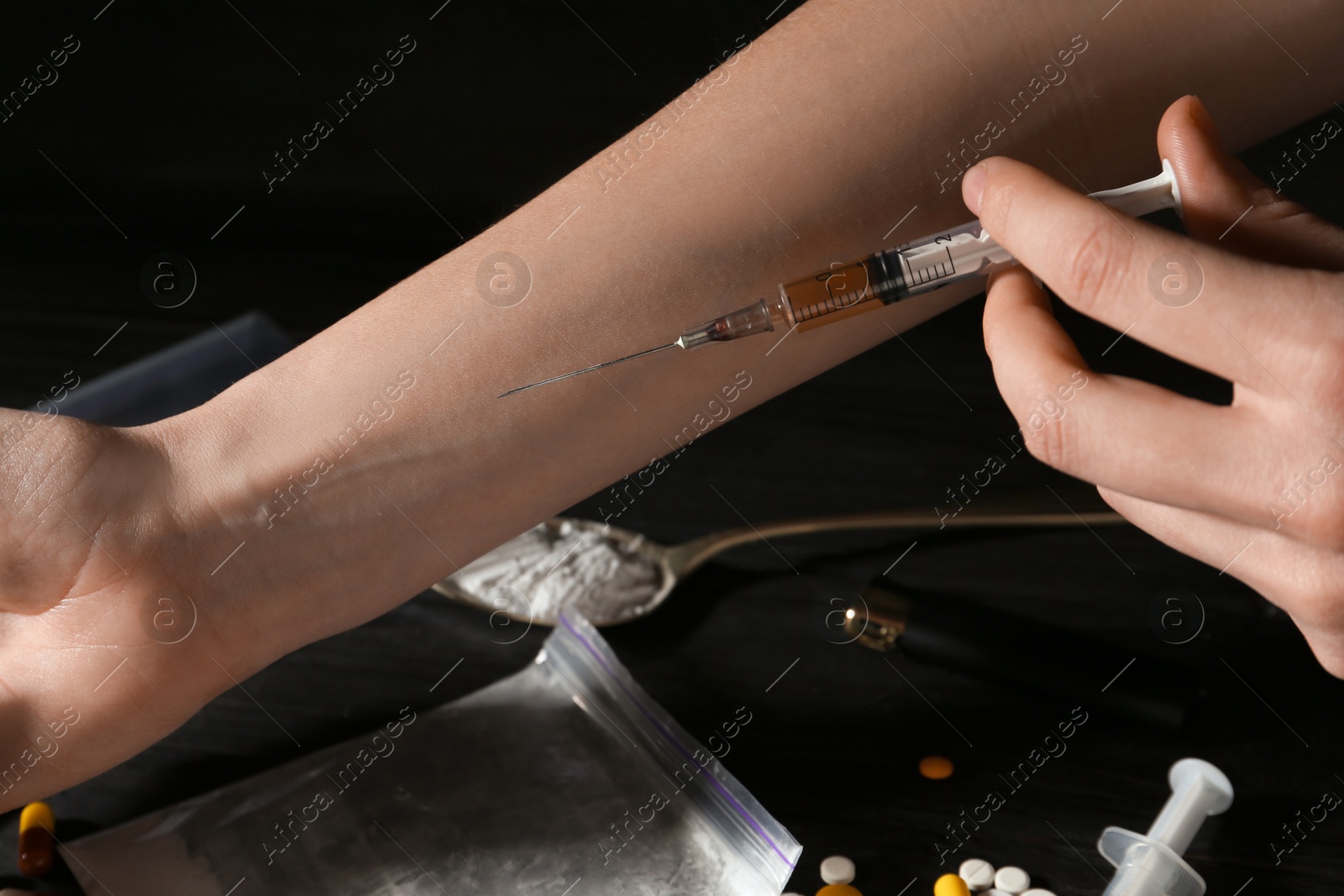 Photo of Drug addiction. Woman with syringe against dark background, closeup