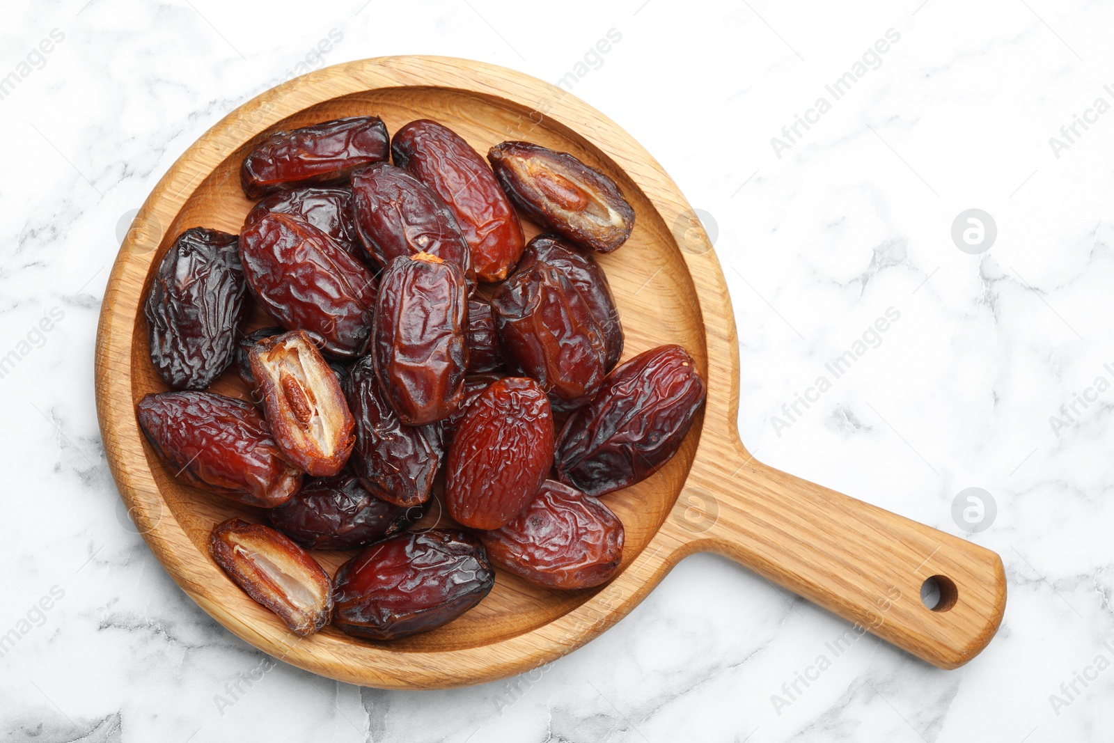 Photo of Many tasty dried dates on white marble table, top view