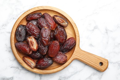 Photo of Many tasty dried dates on white marble table, top view