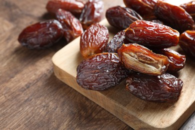 Photo of Many tasty dried dates on wooden table, closeup