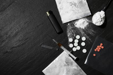 Photo of Flat lay composition with different drugs on black textured table, space for text