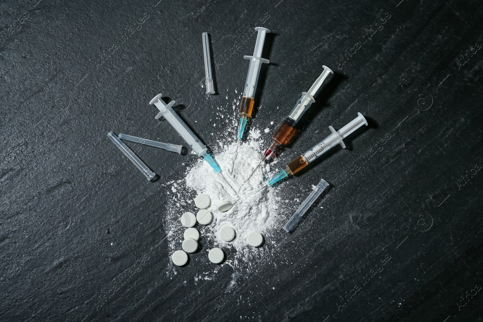 Photo of Drug addiction. Powder, pills and syringes on black textured table, flat lay