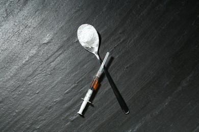 Photo of Drug addiction. Spoon with powder and syringe on dark textured table, flat lay