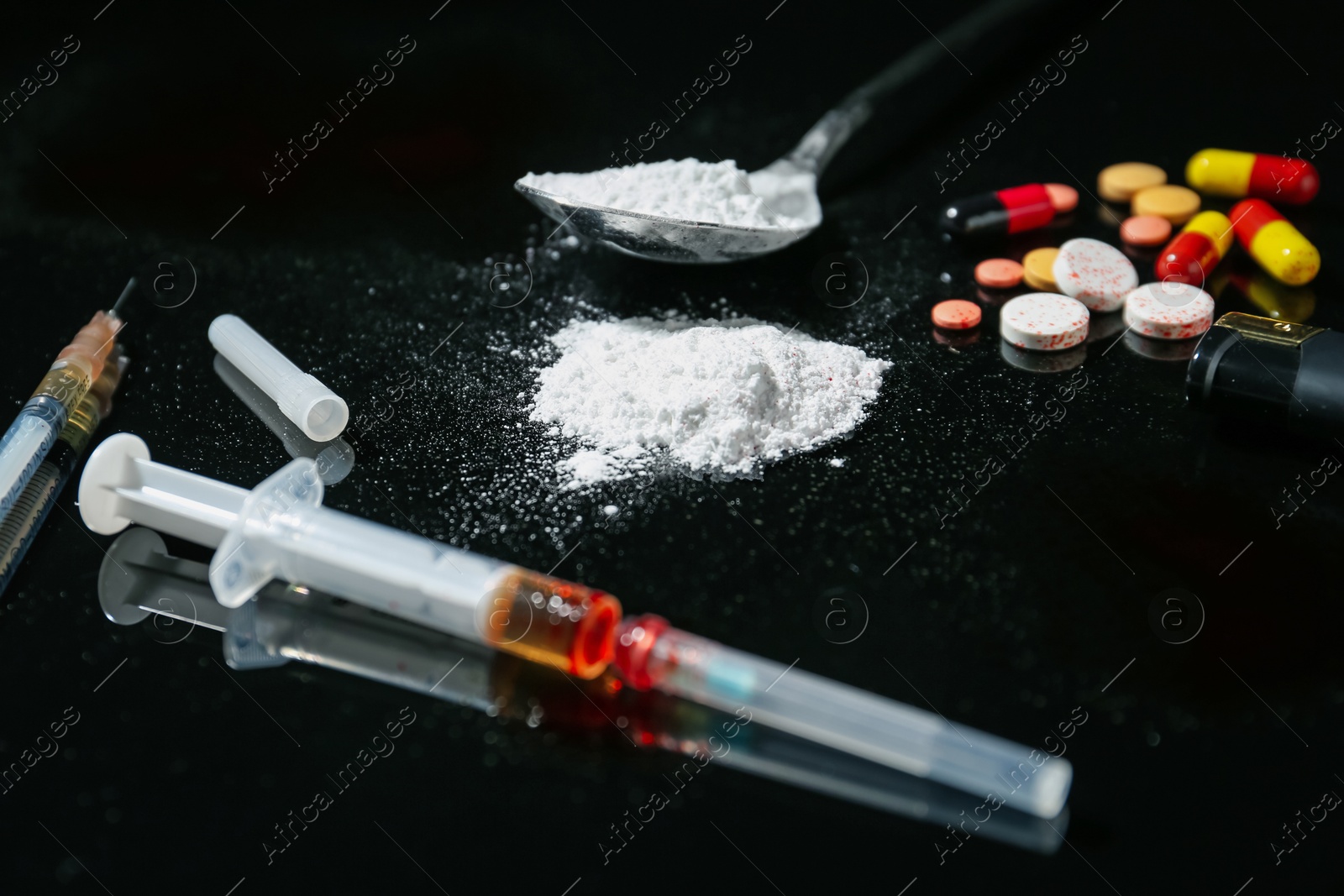 Photo of Drug addiction. Syringes, spoon with powder and pills on black table