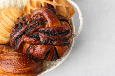 Photo of Different pastries in basket on light table, closeup