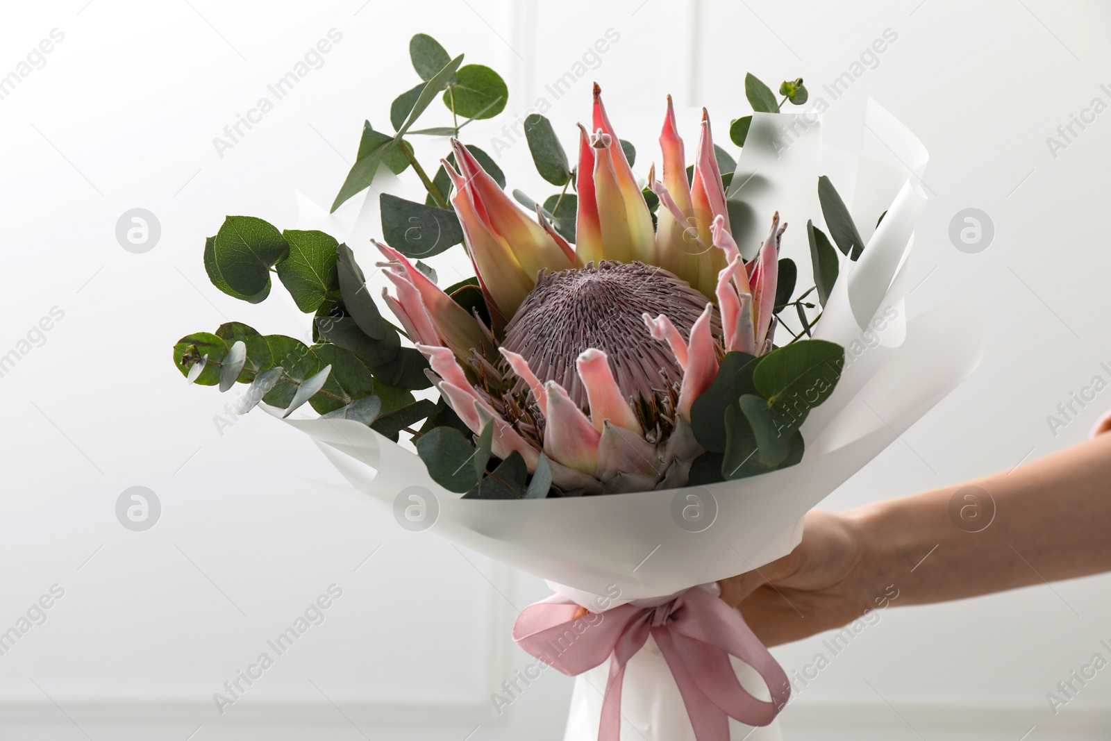 Photo of Woman with beautiful bouquet on light background, closeup