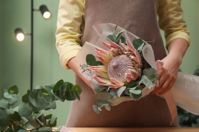 Photo of Florist with beautiful bouquet in flower shop, closeup