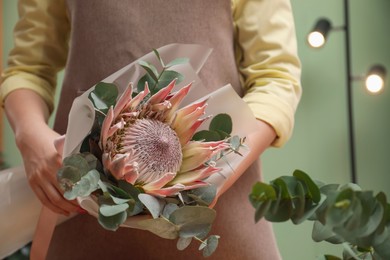 Photo of Florist with beautiful bouquet in flower shop, closeup