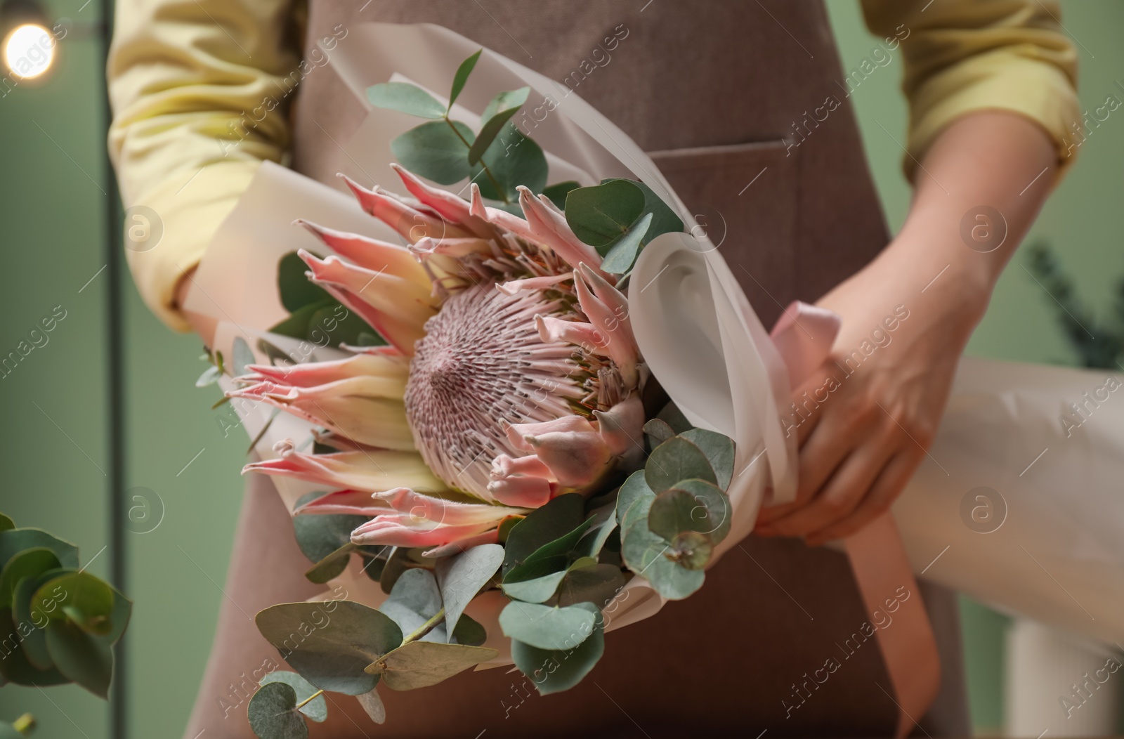 Photo of Florist with beautiful bouquet in flower shop, closeup