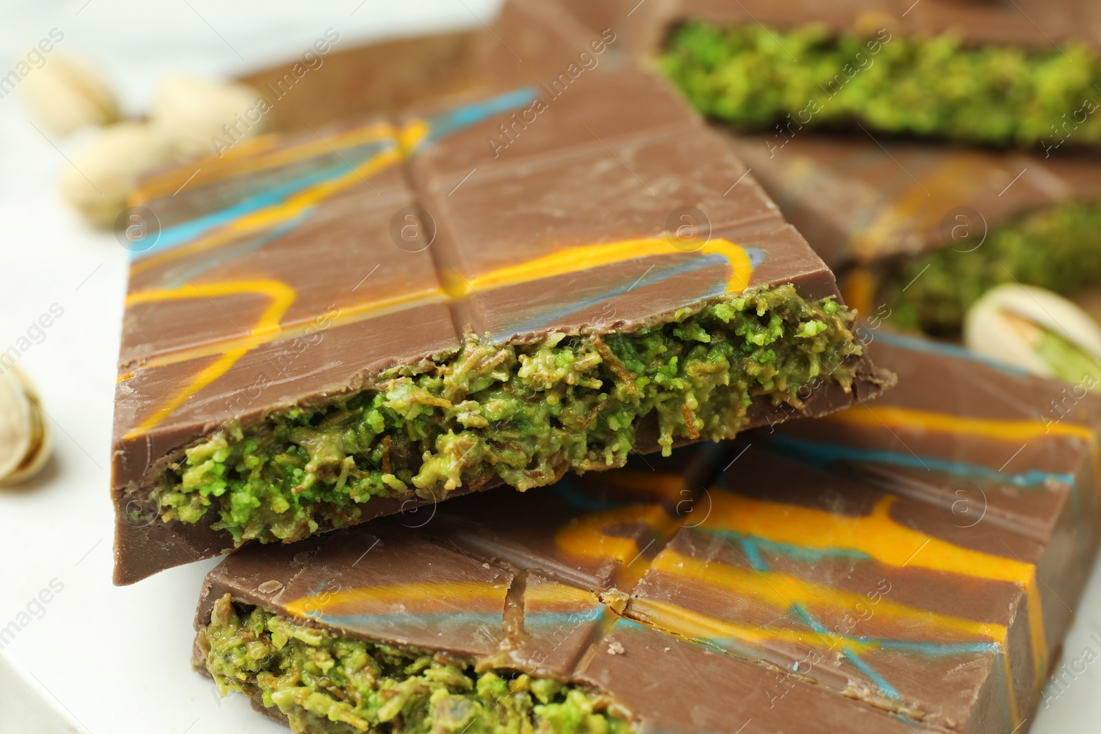 Photo of Pieces of Dubai chocolate bar on white table, closeup