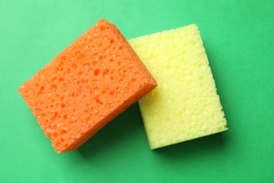 Photo of Soft sponges on green background, top view. Cleaning tool