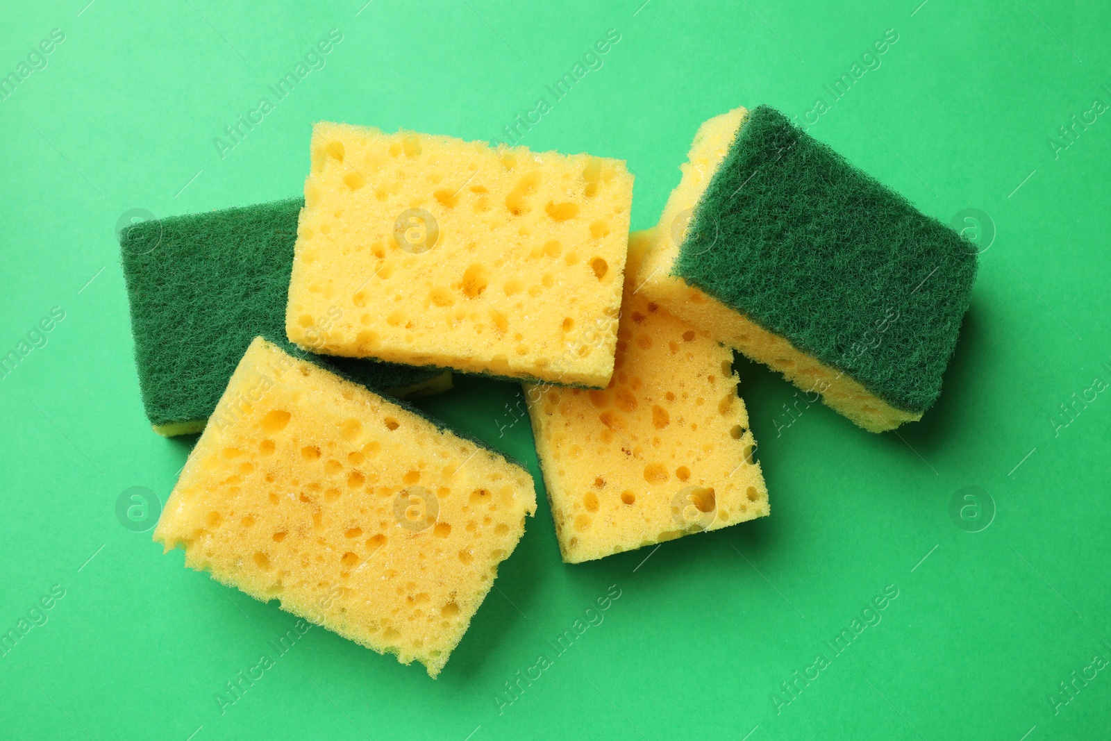 Photo of Soft sponges on green background, top view. Cleaning tool