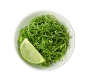 Photo of Lime zest and piece of fruit in bowl isolated on white, top view