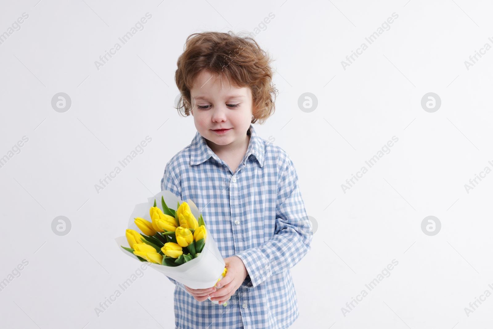 Photo of Cute little boy with bouquet of tulips on white background