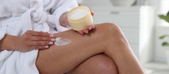 Photo of Woman applying anti cellulite cream indoors, closeup