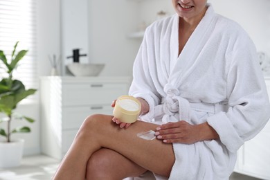 Photo of Woman applying anti cellulite cream indoors, closeup. Space for text