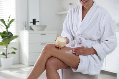 Photo of Woman applying anti cellulite cream indoors, closeup. Space for text