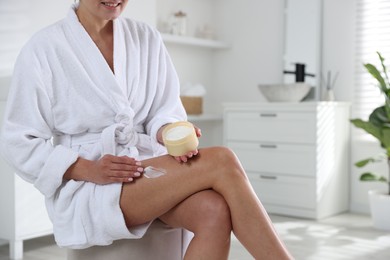 Photo of Woman applying anti cellulite cream indoors, closeup. Space for text