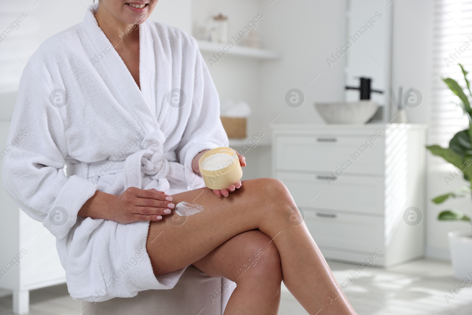 Photo of Woman applying anti cellulite cream indoors, closeup. Space for text