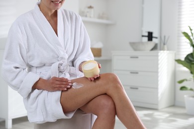 Woman applying anti cellulite cream indoors, closeup. Space for text