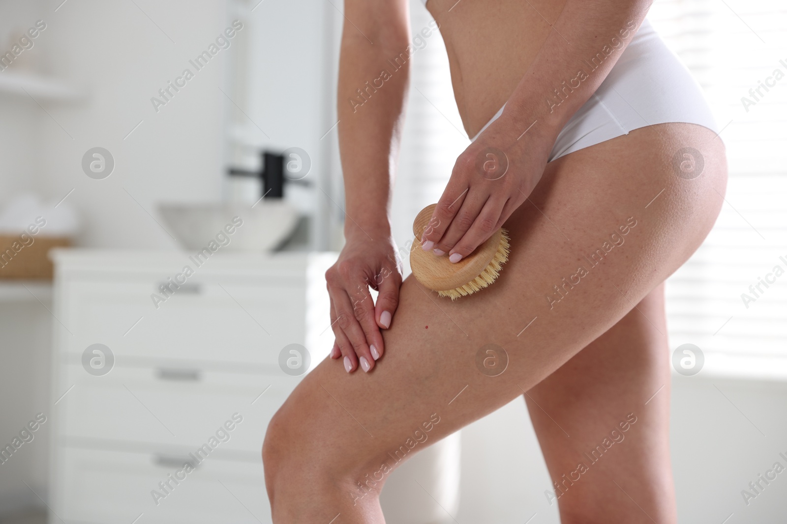 Photo of Woman doing anti cellulite massage with brush indoors, closeup. Space for text