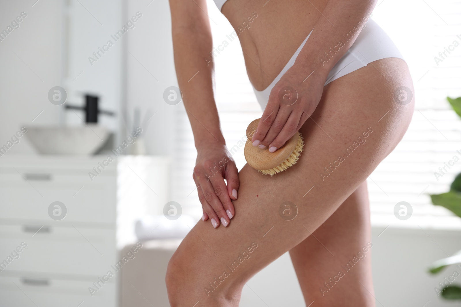 Photo of Woman doing anti cellulite massage with brush indoors, closeup. Space for text