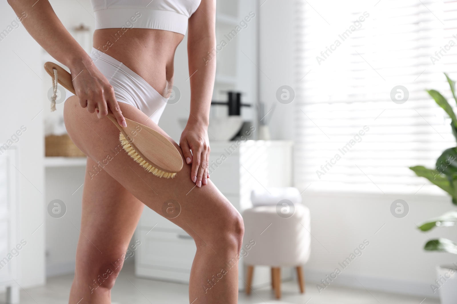 Photo of Woman doing anti cellulite massage with brush indoors, closeup. Space for text