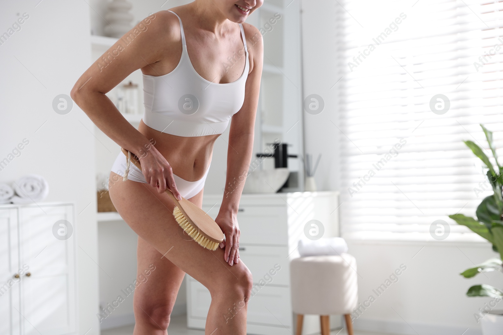 Photo of Woman doing anti cellulite massage with brush indoors, closeup. Space for text