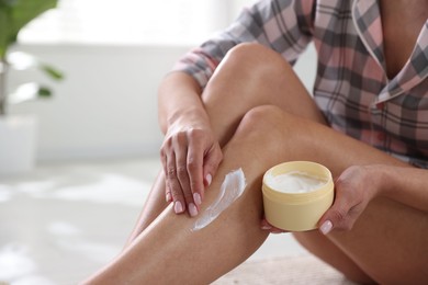 Photo of Woman applying anti cellulite cream indoors, closeup. Space for text