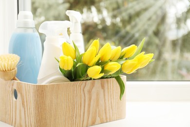 Photo of Spring cleaning. Detergents, supplies and tulips on windowsill indoors, space for text