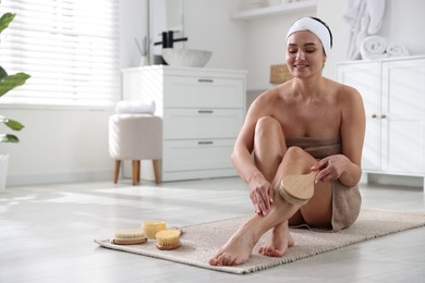 Photo of Woman doing anti cellulite massage with brush indoors. Space for text