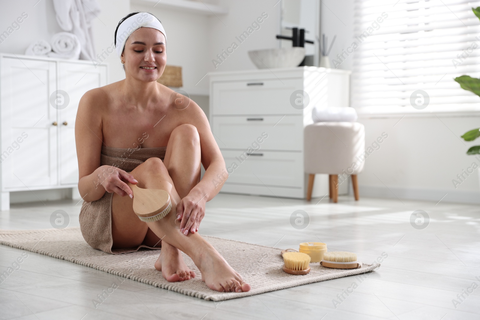 Photo of Woman doing anti cellulite massage with brush indoors. Space for text