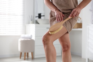 Photo of Woman doing anti cellulite massage with brush indoors, closeup. Space for text