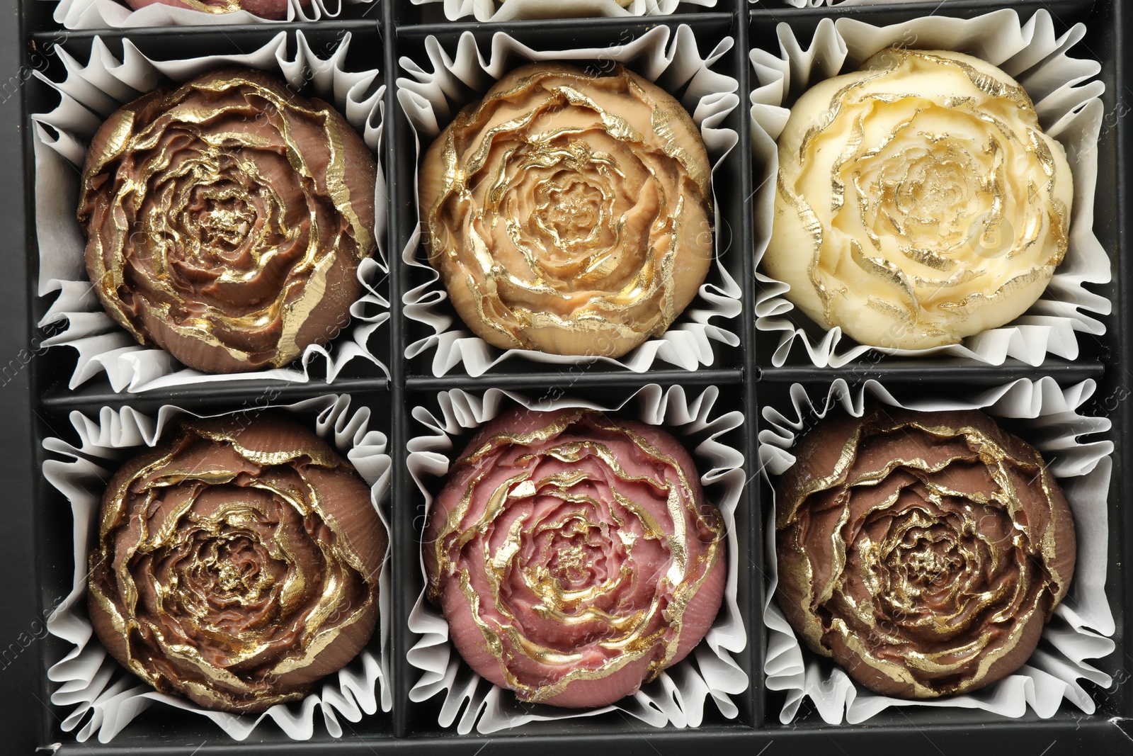 Photo of Flower shaped chocolate bonbons in box, top view