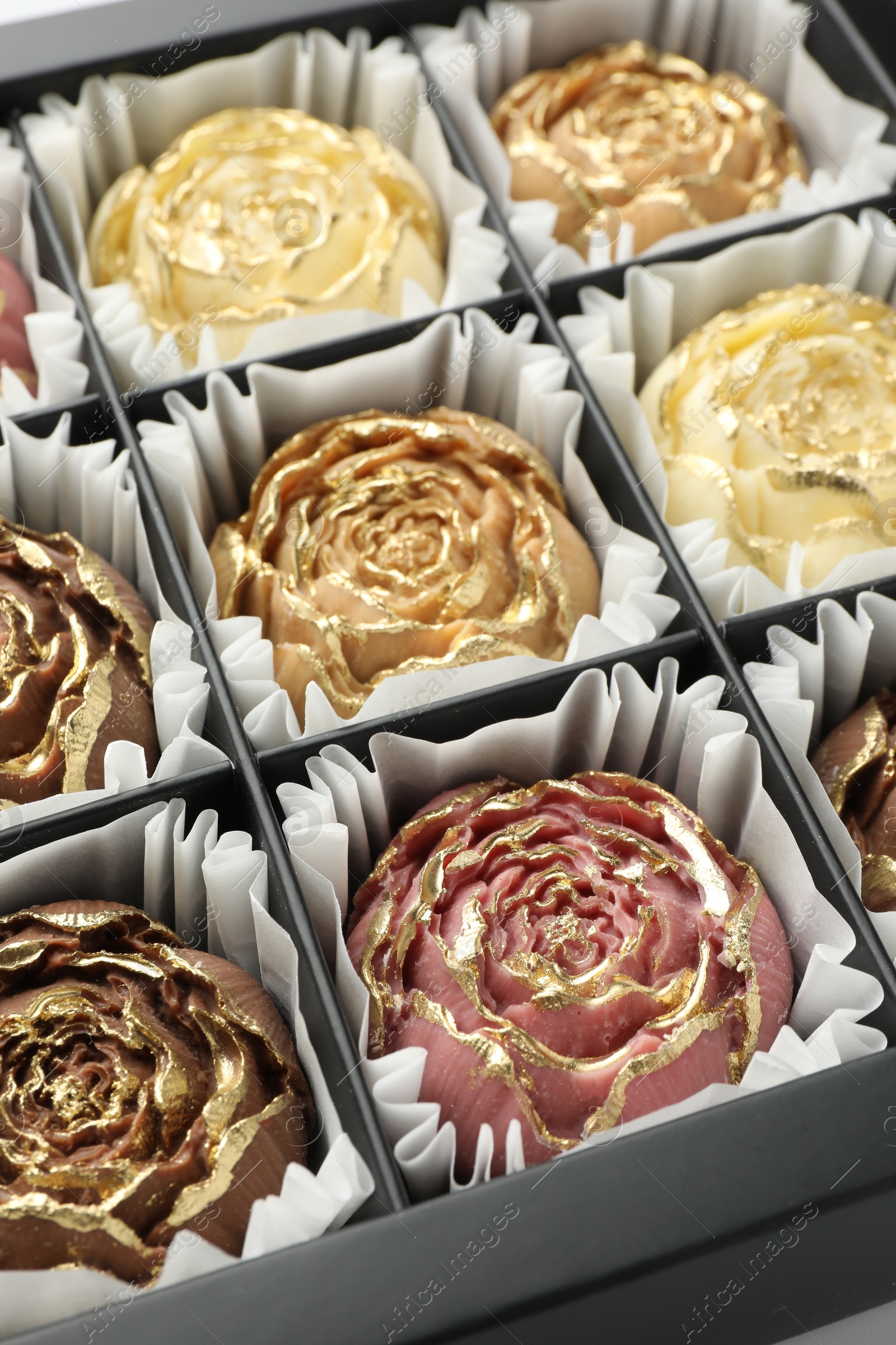 Photo of Flower shaped chocolate bonbons in box, closeup