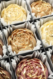 Photo of Flower shaped chocolate bonbons in box, closeup