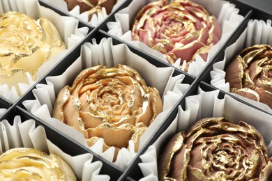 Photo of Flower shaped chocolate bonbons in box, closeup