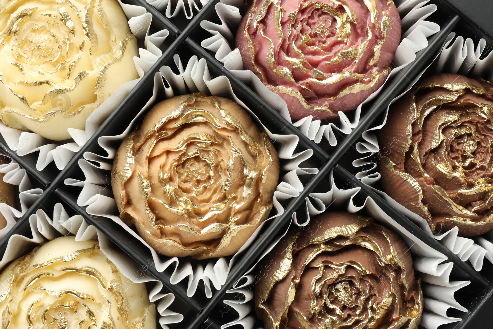 Photo of Flower shaped chocolate bonbons in box, top view