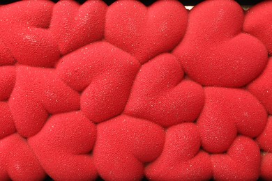 Photo of Chocolate bar decorated with hearts as background, top view